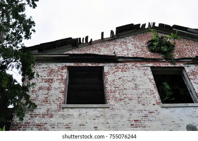 Old abandoned big brick building with broken windows and broken roof