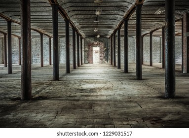 Old abandoned brick built Victorian warehouse interior with iron pillars. Uk.