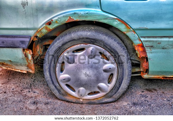 old abandoned old car\
with a flat tire