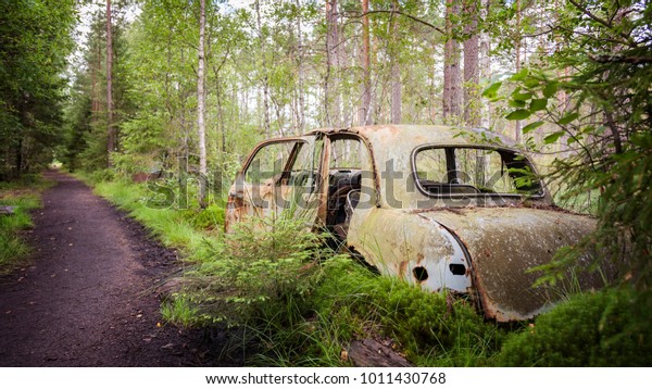 Old abandoned car in the\
forest. 