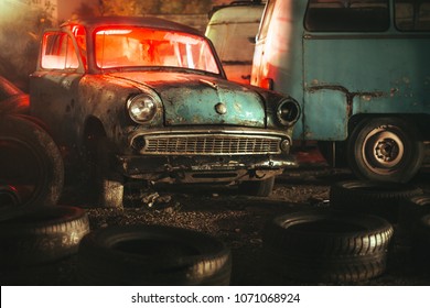 Old Abandoned Car In A Junkyard At Night With Red Light