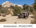 An old abandoned car sits derelict and rotting on the Wall Street Mill Trail in Joshua Tree National Park, California.