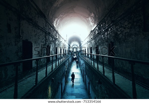 東国刑務所の廃墟となった独房で 暗いトンネルの端の明かりのところを歩く人々 の写真素材 今すぐ編集