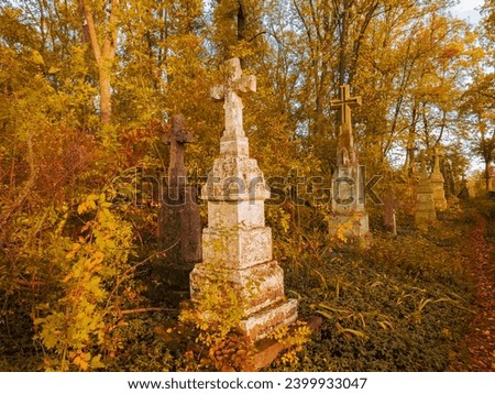 Old abandoned Christian cemetery. Graves, tombstones and crosses. Sunny morning at the autumn cemetery.