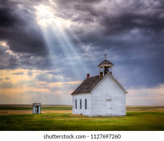 Old abandoned church at sunset with a beam of light shining down upon it.