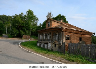 An old abandoned dilapidated wooden house of the 19th century at the turn of the road in Ples, Russia - Powered by Shutterstock