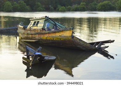 Old abandoned fisherman boat on the riverside.