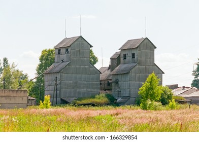 Old abandoned grain elevator against blue sky background. 