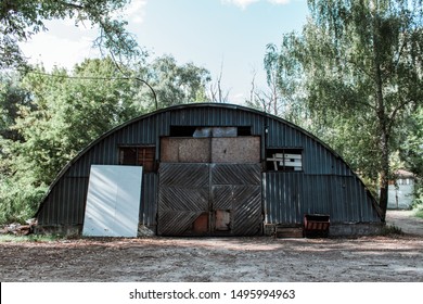 Old abandoned hangar with a wooden gate. Facade of an old hangar - Powered by Shutterstock