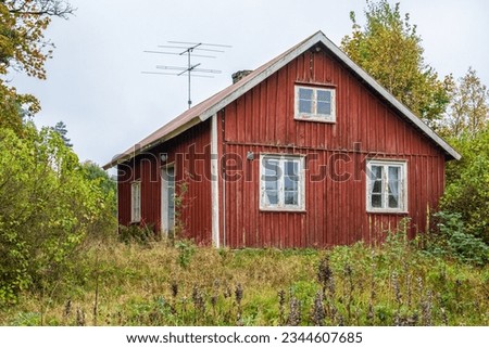 Old abandoned house with a overgrown garden at autumn