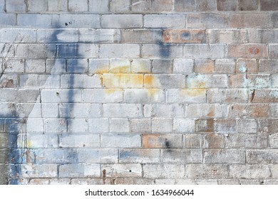 Old Abandoned Industrial Warehouse Exposed Brick Wall With Worn Weathered Paint And Graffiti 