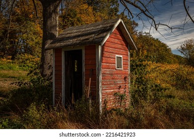 Old abandoned outhouse in autumn