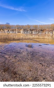 Old abandoned quarry with water at the rock face - Shutterstock ID 2255573291