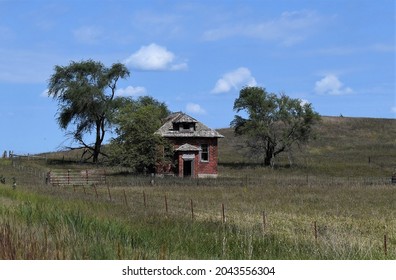 Old Abandoned, Red Brick School House Slowly Decaying In The Midwest From A Distance