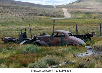 Old Abandoned Retro Car And Flat Bed Truck In A Grassy Field.