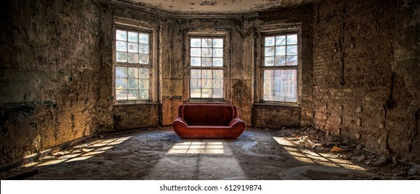 Old and abandoned room with three big broken windows and a red couch - Shutterstock ID 612919874