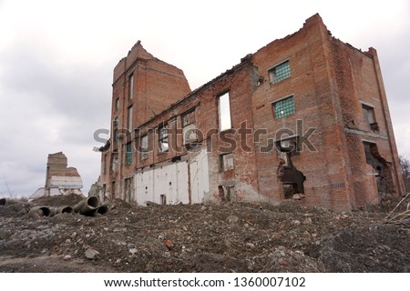 Old abandoned ruined building. Old sugar-mill. Collapsed brick-wall industrial buildings. Demolished plants. Ruins of the factory sugar refinery. 