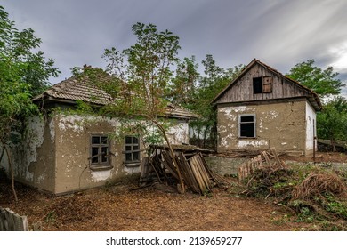 Old abandoned ruined house in dead village. Deserted and destroyed dwelling on farm yard. Neglected building countryside