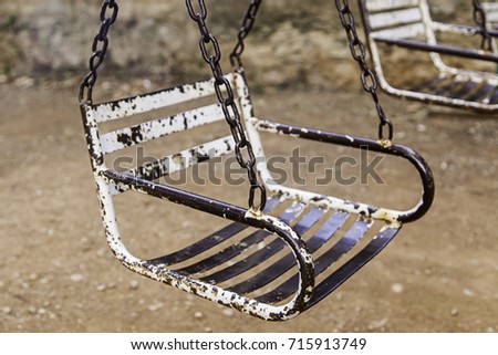 Old abandoned and rusted swings, children game detail