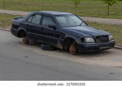 Old abandoned rusty car without wheels on the side of the road - Shutterstock ID 2170392333