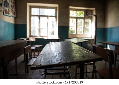 Old And Abandoned School Classroom Interior. Dirty Grunge Room With Windows And Desks. Selective Focus