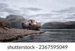 An old abandoned ship on the coast in Fort William town in Scotland surrounded by hills