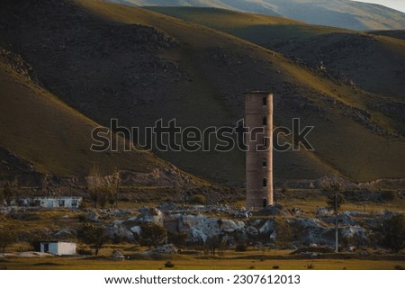 Old abandoned tower on mountains background, Kyrgyzstan