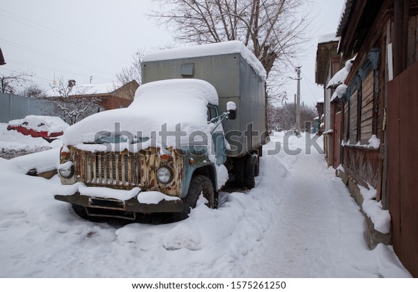 old abandoned\
truck in winter under the\
snow