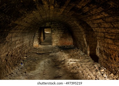 Old abandoned tunnel in the underground wine cellar. Entrance to the catacombs in Odessa, Ukraine. As a creative background for a dark design step. Selective focus.