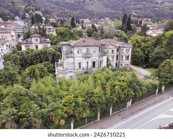 An old, abandoned villa in Italy, with cracked walls, overgrown plants, and a rusty gate. The villa was built in the 1850s. It is now a popular destination for urban explorers and photographers. - Powered by Shutterstock