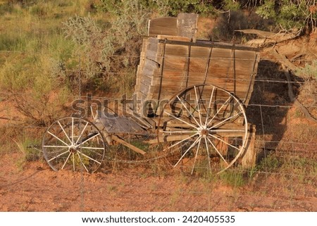 Old, abandoned wagon near a fence alongside a rural road in Utah