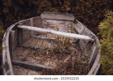 An old abandoned wooden boat in the bushes and grass - Powered by Shutterstock