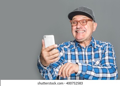 Old Active Man Taking Selfie With Mobile Phone Isolated On Grey Background