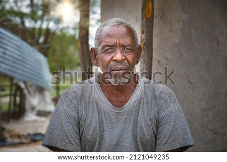 old african man in front of the house in an african village
