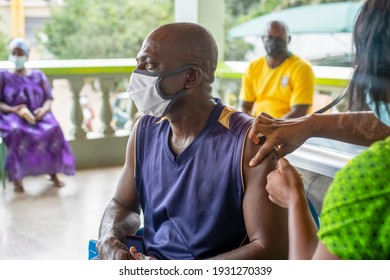 An old African man receiving a vaccine injection from a healthcare provider