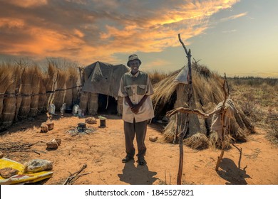 old African man standing in front of his home in a village in Botswana