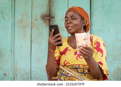 old african woman holding her phone and money
