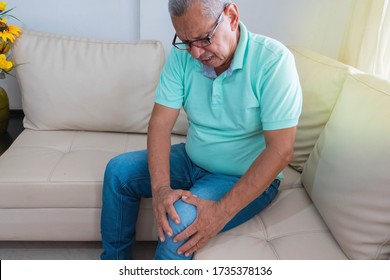 Old Age, Health Problem. Older Man Suffering From Leg Pain At Home