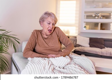 Old Age, Health Problem And People Concept - Senior Woman Suffering From Stomach Ache At Home. Senior Woman Suffering From Stomach Pain At Home