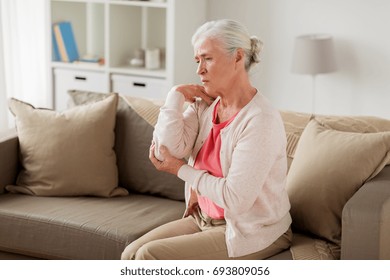 Old Age, Health Problem And People Concept - Senior Woman Suffering From Pain In Hand At Home