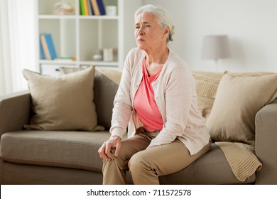 Old Age, Health Problem And People Concept - Senior Woman Suffering From Pain In Leg At Home