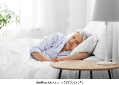 old age and people concept - senior woman sleeping in bed at home bedroom - Powered by Shutterstock