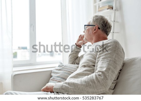 Similar – Image, Stock Photo Concept of depression. Old man staring at nothing in the dark in black and white with a black background