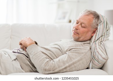 old age, rest, comfort and people concept - senior man sleeping on sofa at home - Powered by Shutterstock