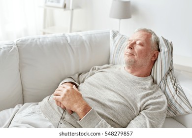 Old Age, Rest, Comfort And People Concept - Senior Man Sleeping On Sofa At Home