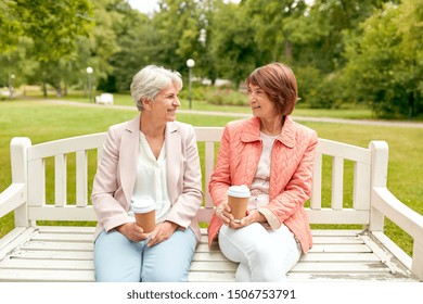 Old Age, Retirement And People Concept - Two Senior Women Or Friends Drinking Coffee And Talking At Park