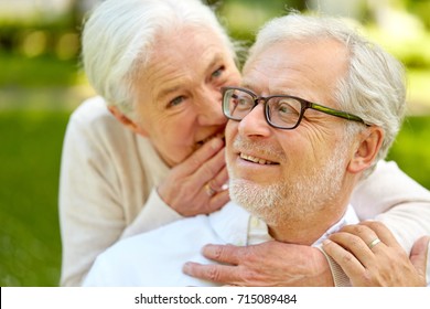 old age, retirement and people concept - close up of happy senior couple whispering outdoors
