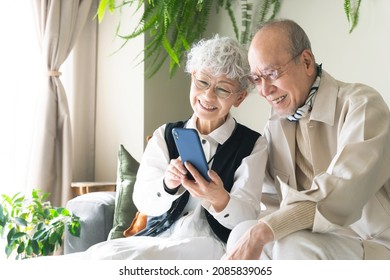 Old Aged Asian Couple Using A Smart Phone.