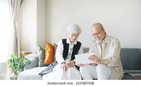Old aged Asian couple using a tablet PC.