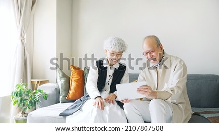 Old aged Asian couple using a tablet PC.